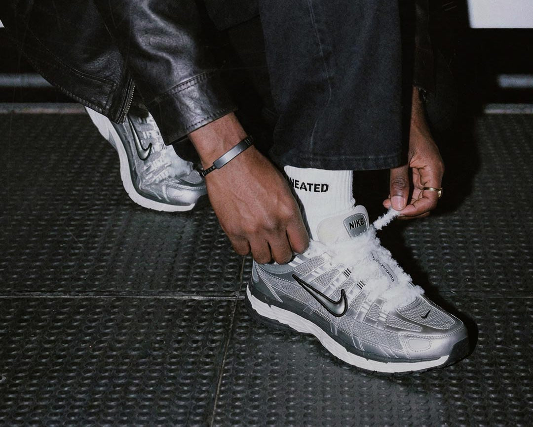 Person zieht weiße SNEATED Fuzzy Laces an Sneakern fest - flauschige Sneaker Laces